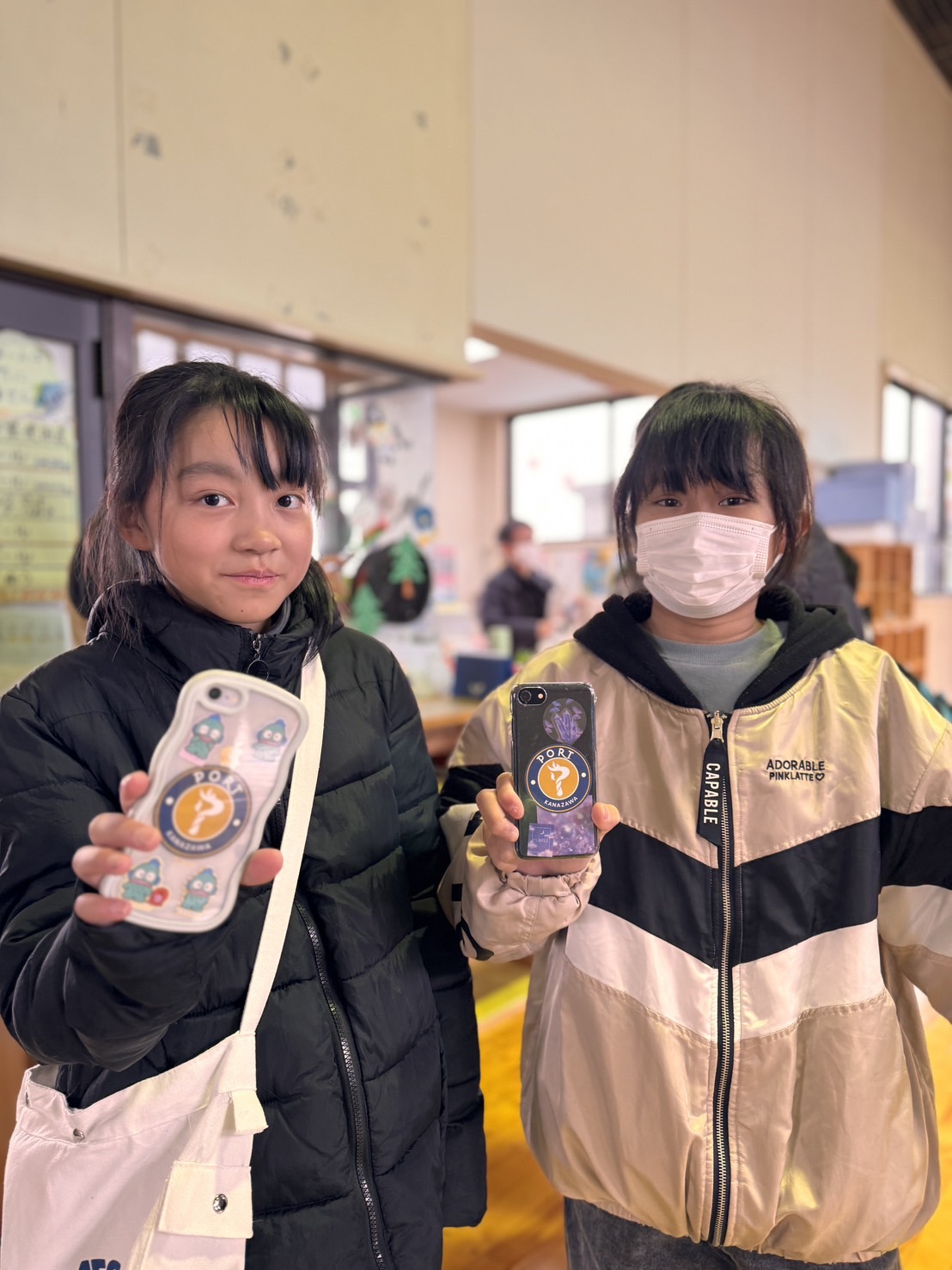 金沢ポートのステッカーを見せる三和児童館の子どもたち